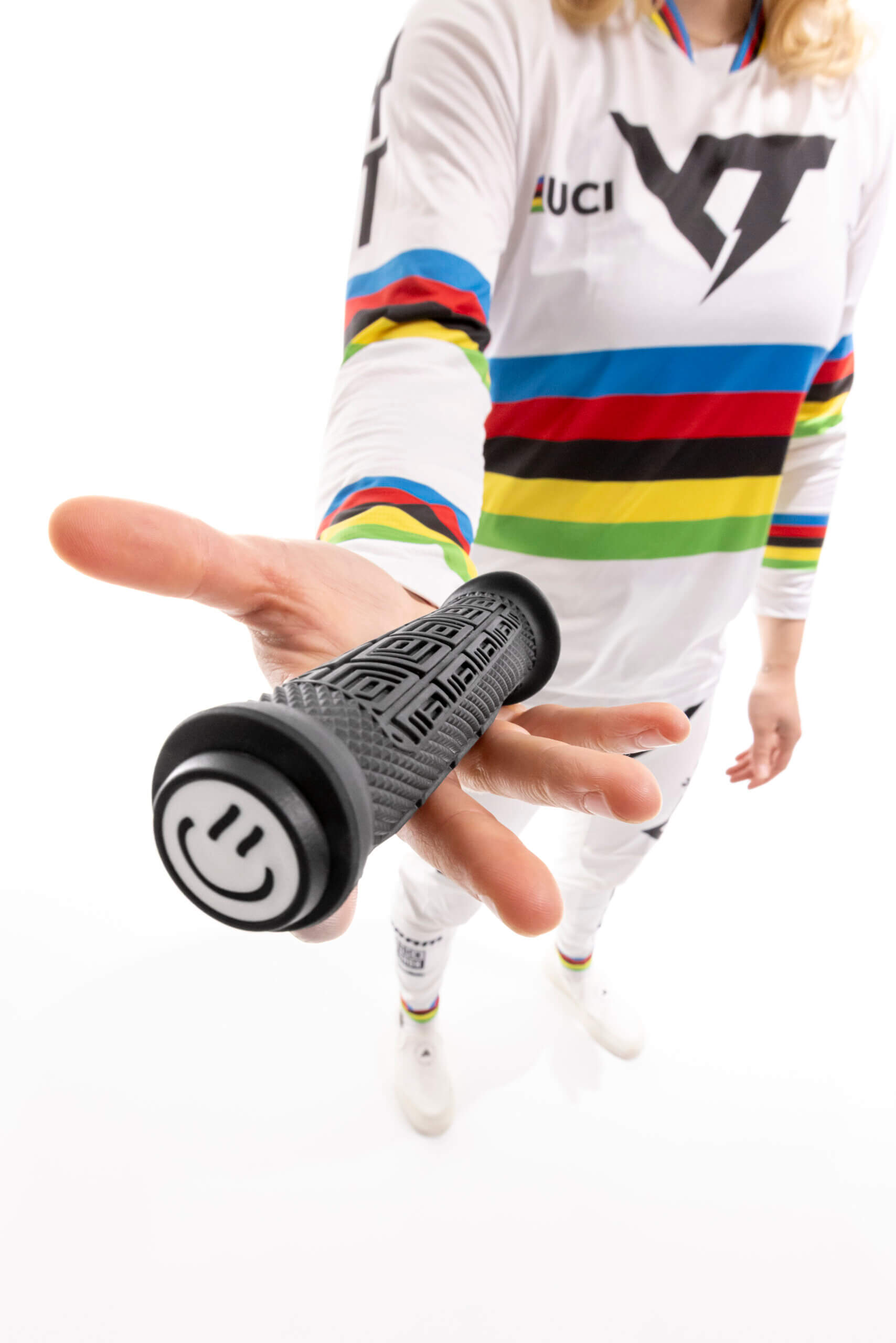 Fahrradfahrer hält schwarzen Lenkergriff mit Smiley-Kappe.